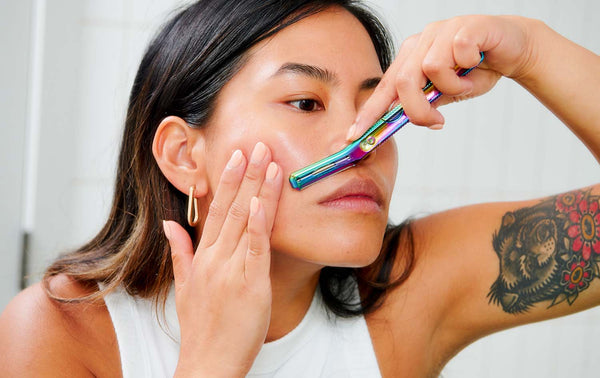 women dermaplaning her face